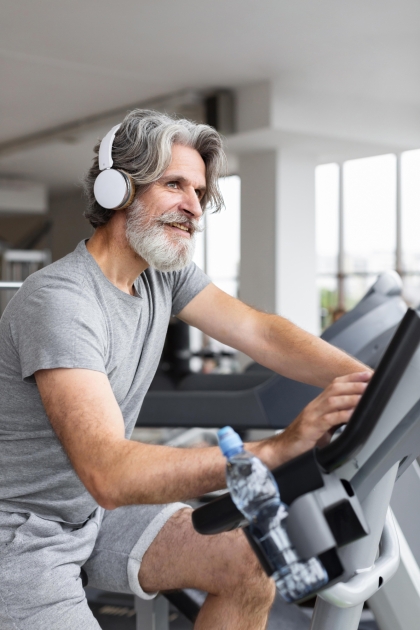 older man riding a stationary bike
